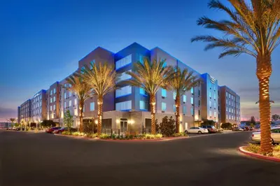 a building with palm trees in front of a street at TownePlace Suites by Marriott Los Angeles LAX/Hawthorne in Hawthorne