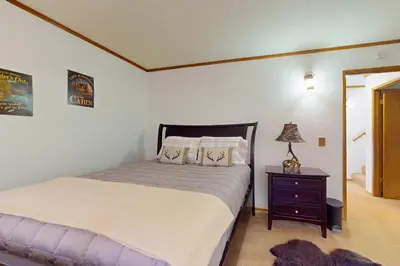 a bedroom with a large bed and a night stand at Victoria Court Vacation in Lake Arrowhead