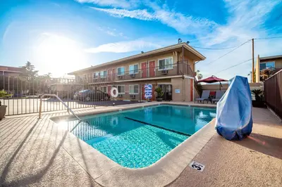 a swimming pool with a slide in front of a building at Friendly Hills Inn - Whittier, Los Angeles in Whittier