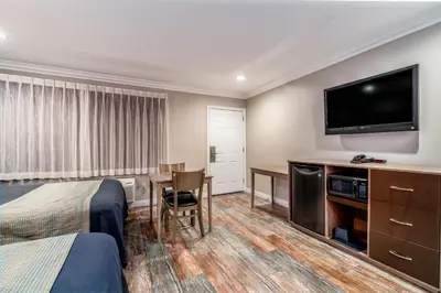 a hotel room with a bed and a flat screen tv at Friendly Hills Inn - Whittier, Los Angeles in Whittier