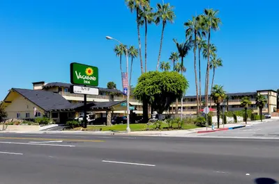 a view of a hotel with a sign and palm trees at Vagabond Inn Whittier in Whittier