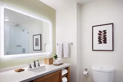 a white bathroom with a sink and a mirror at Ambrose Hotel in Los Angeles