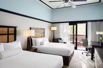 a hotel room with two beds and a desk at Ambrose Hotel in Los Angeles