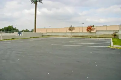 an empty parking lot with a building in the background at La Mirage Inn LAX Airport in Los Angeles