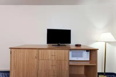 a television on top of a microwave on a cabinet at Days Inn by Wyndham Anaheim West in Anaheim