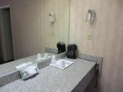 a bathroom counter with a sink and a mirror at Days Inn by Wyndham Anaheim West in Anaheim