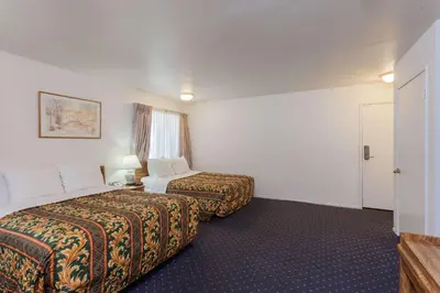a hotel room with two beds and a window at Days Inn by Wyndham Anaheim West in Anaheim