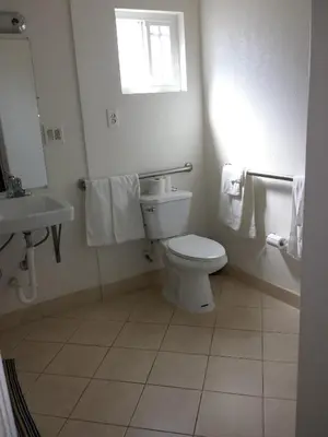 a bathroom with a toilet and a sink at New Kansan Motel in Rancho Cucamonga