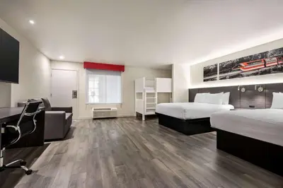 a hotel room with two beds and a desk at Ramada by Wyndham Anaheim Convention Center in Anaheim