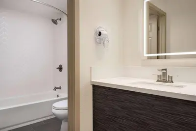 a bathroom with a sink and a toilet and a mirror at Ramada by Wyndham Anaheim Convention Center in Anaheim