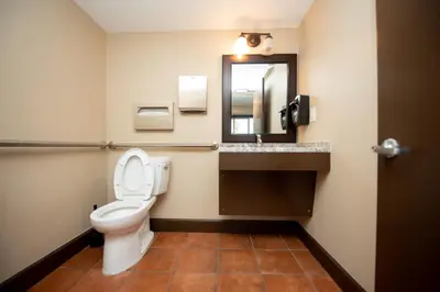a bathroom with a toilet and a sink and a mirror at Casa Bella Inn- Huntington Park in Huntington Park