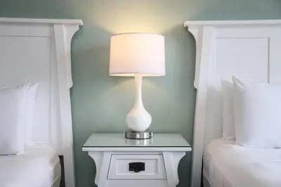 a lamp on a night stand next to two beds at Hotel Carmel Santa Monica in Los Angeles