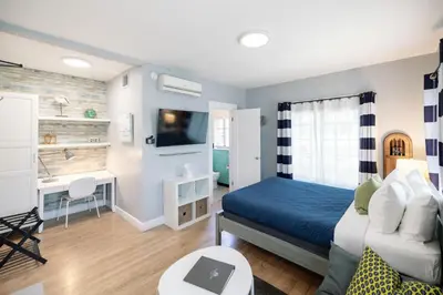 a bedroom with a bed and a desk and a couch at Broadlind Hotel in Long Beach