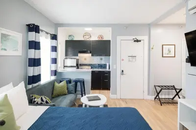 a living room with a bed and a kitchen at Broadlind Hotel in Long Beach