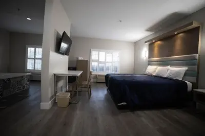 a bedroom with a bed and a desk and a television at Mid City Inn & Suites Pico Rivera in Pico Rivera