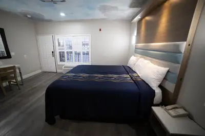 a hotel room with a bed and a window at Mid City Inn & Suites Pico Rivera in Pico Rivera