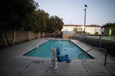 a swimming pool with a chair in front of a building at Mid City Inn & Suites Pico Rivera in Pico Rivera