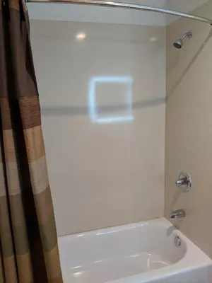 a bathroom with a shower and a white sink at Epic Hotel in Pico Rivera
