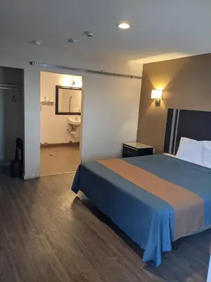 a hotel room with a bed and a bathroom at Epic Hotel in Pico Rivera