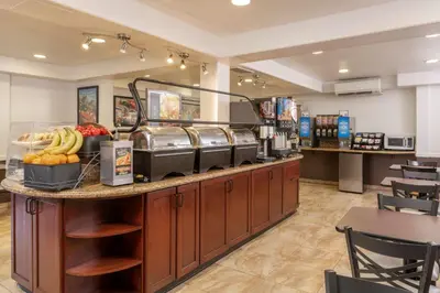 a restaurant with a counter with fruit on it at Best Western Plus Raffles Inn & Suites in Anaheim