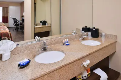 a bathroom with two sinks in a hotel room at Best Western Plus Raffles Inn & Suites in Anaheim