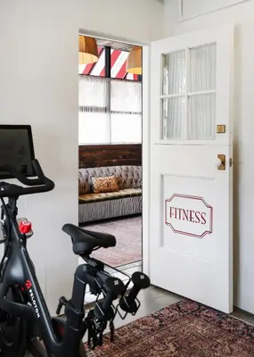a bike parked in front of a door with a fitness sign at Palihotel Melrose in Los Angeles