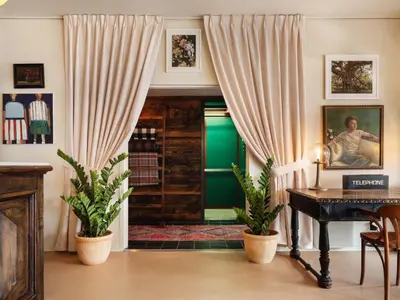 a living room with a green door and a piano at Palihotel Melrose in Los Angeles