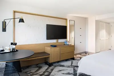 a bedroom with a bed and a desk with a television at Sheraton Cerritos in Buena Park