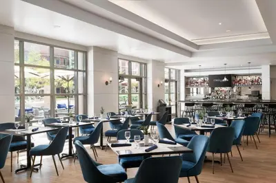 a restaurant with tables and chairs and a bar at Sheraton Cerritos in Buena Park