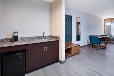 a kitchen with a sink and a dining room at Holiday Inn Ontario Airport - California by IHG in Ontario