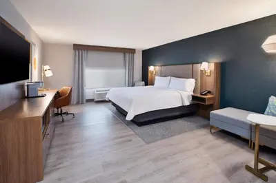 a hotel room with a bed and a flat screen tv at Holiday Inn Ontario Airport - California by IHG in Ontario