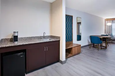 a kitchen with a sink and a dining room at Holiday Inn Ontario Airport - California by IHG in Ontario