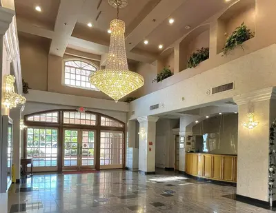 a large lobby with a chandelier in a building at Park Suites Hotel in South El Monte