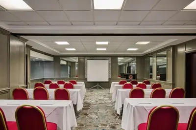 a conference room with white tables and red chairs at DoubleTree by Hilton Chatsworth in Chatsworth
