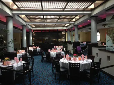 a dining room with tables and chairs with pink roses on them at DoubleTree by Hilton Chatsworth in Chatsworth