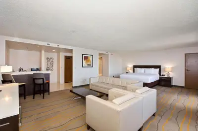 a hotel room with a bed and a living room at Doubletree by Hilton Whittier in Whittier