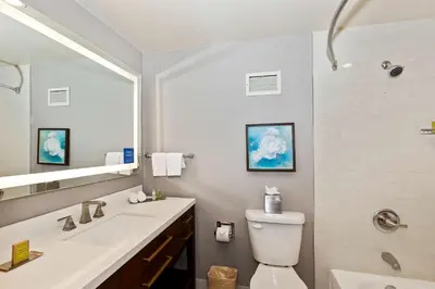 a bathroom with a sink and a toilet and a mirror at Doubletree by Hilton Whittier in Whittier