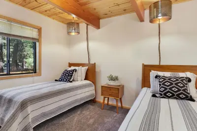 two beds in a bedroom with wooden ceilings at Dreams of Summit-1120 by Big Bear Vacations in Big Bear Lake