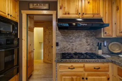 a kitchen with wooden cabinets and a stove top oven at All About Fun-1149 by Big Bear Vacations in Big Bear Lake