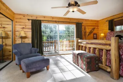 a bedroom with a bed and chairs and a window at All About Fun-1149 by Big Bear Vacations in Big Bear Lake