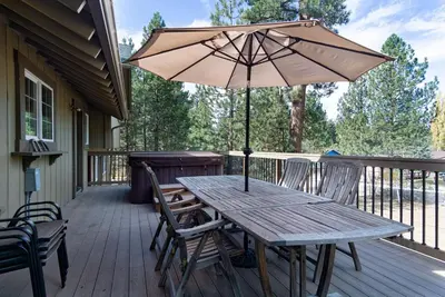 a wooden table with an umbrella on a deck at All About Fun-1149 by Big Bear Vacations in Big Bear Lake