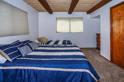 a bedroom with two beds with blue and white sheets at Lakeview Fishing House-121 by Big Bear Vacations in Big Bear Lake