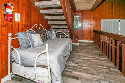 a bedroom with a bed in a room with wooden walls at Lakeview Fishing House-121 by Big Bear Vacations in Big Bear Lake