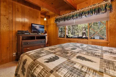 a bedroom with a bed and a television and a window at Moose Creek Chalet-1237 by Big Bear Vacations in Big Bear Lake