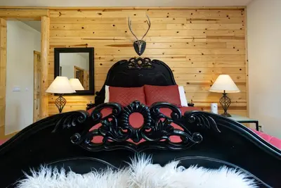 a bedroom with a black bed with red pillows at Eagle Ridge Views-1648 by Big Bear Vacations in Big Bear Lake