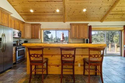 a kitchen with a wooden counter and two chairs at Eagle Ridge Views-1648 by Big Bear Vacations in Big Bear Lake
