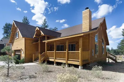 a log home with a porch and a chimney at Eagle Ridge Views-1648 by Big Bear Vacations in Big Bear Lake