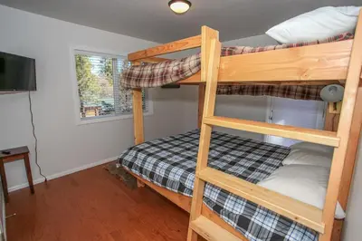 a bedroom with two bunk beds and a television at Mountain Modern-1743 by Big Bear Vacations in Big Bear Lake