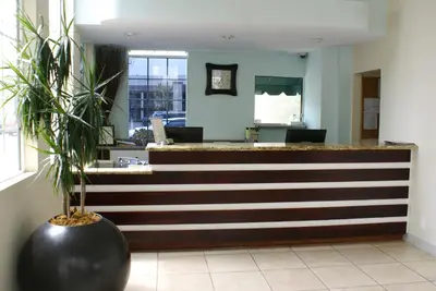 a lobby with a reception desk with a plant at Queens Inn Anaheim in Anaheim