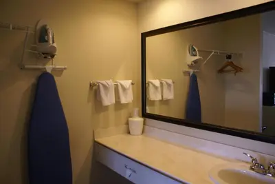 a bathroom with a sink and a large mirror at Queens Inn Anaheim in Anaheim